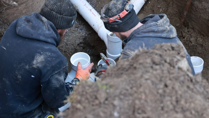 JMS technicians installing pipe